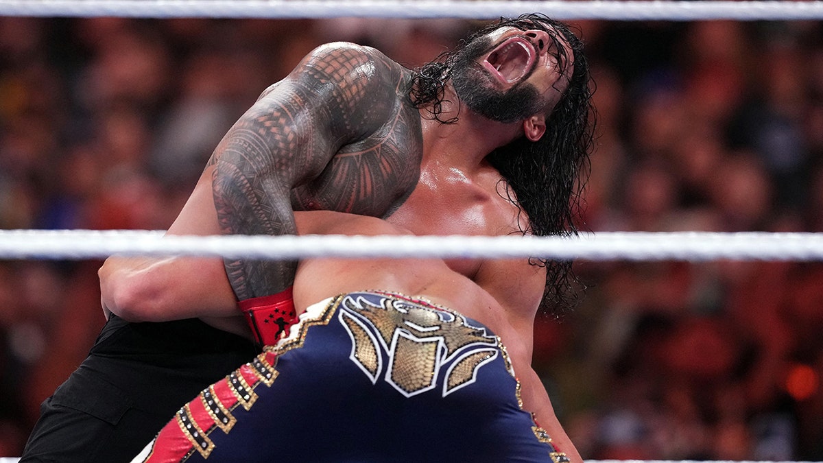 Roman Reigns puts Cody Rhodes in a submission hold