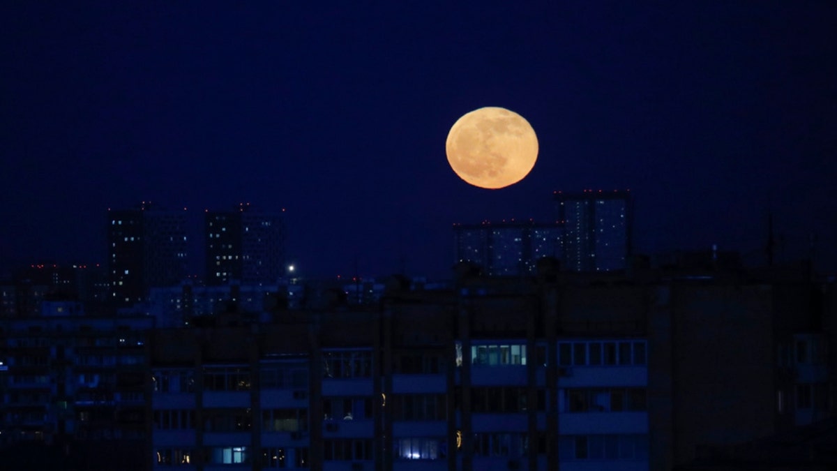 The moon rises over Moscow, Russia