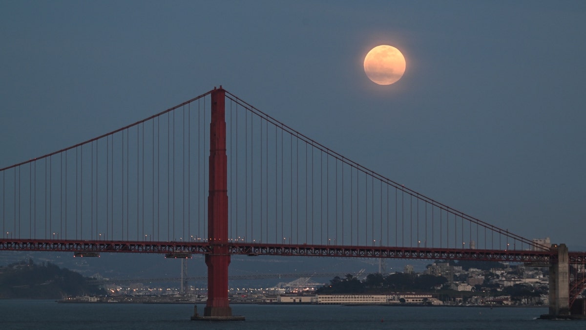 A full pink moon over San Francisco's Golden Gate Bridge