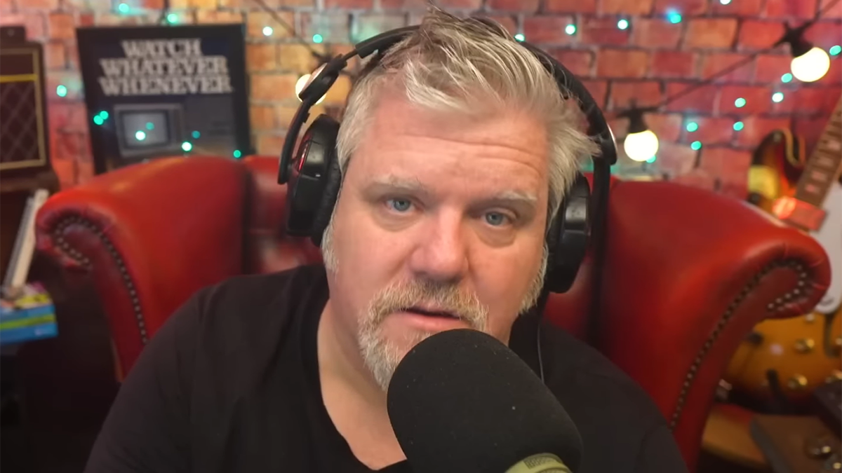 Craig Duncan in a black shirt speaks into a microphone wearing black headphones talking about his time with James Corden