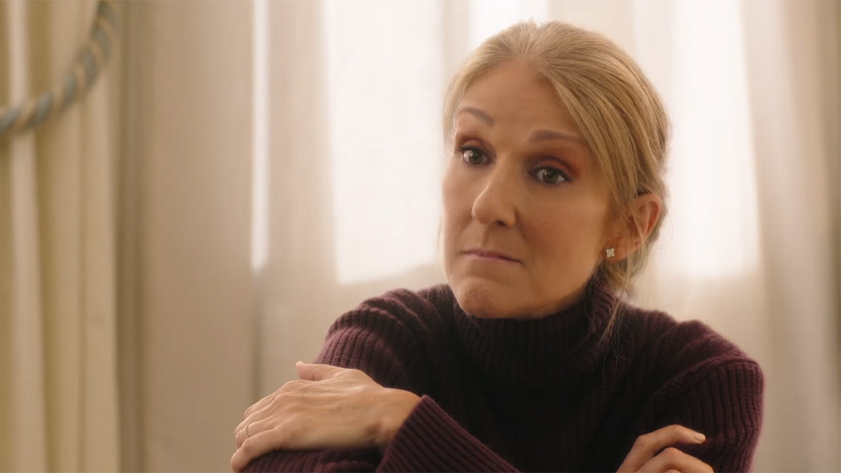 Celine Dion está com os braços cruzados e parece um pouco perplexa no filme "Amar de novo"