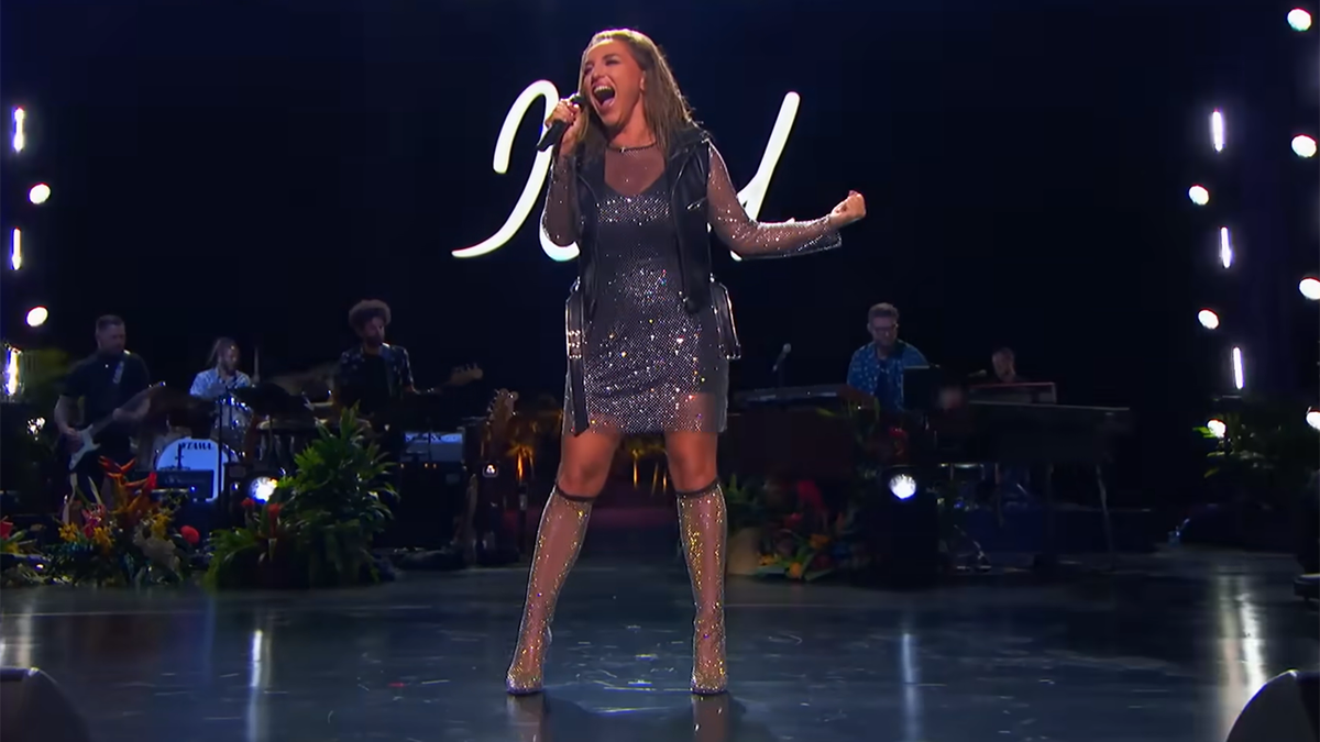 Nutsa wears a glittery dress and stockings on stage while performing on "American Idol"