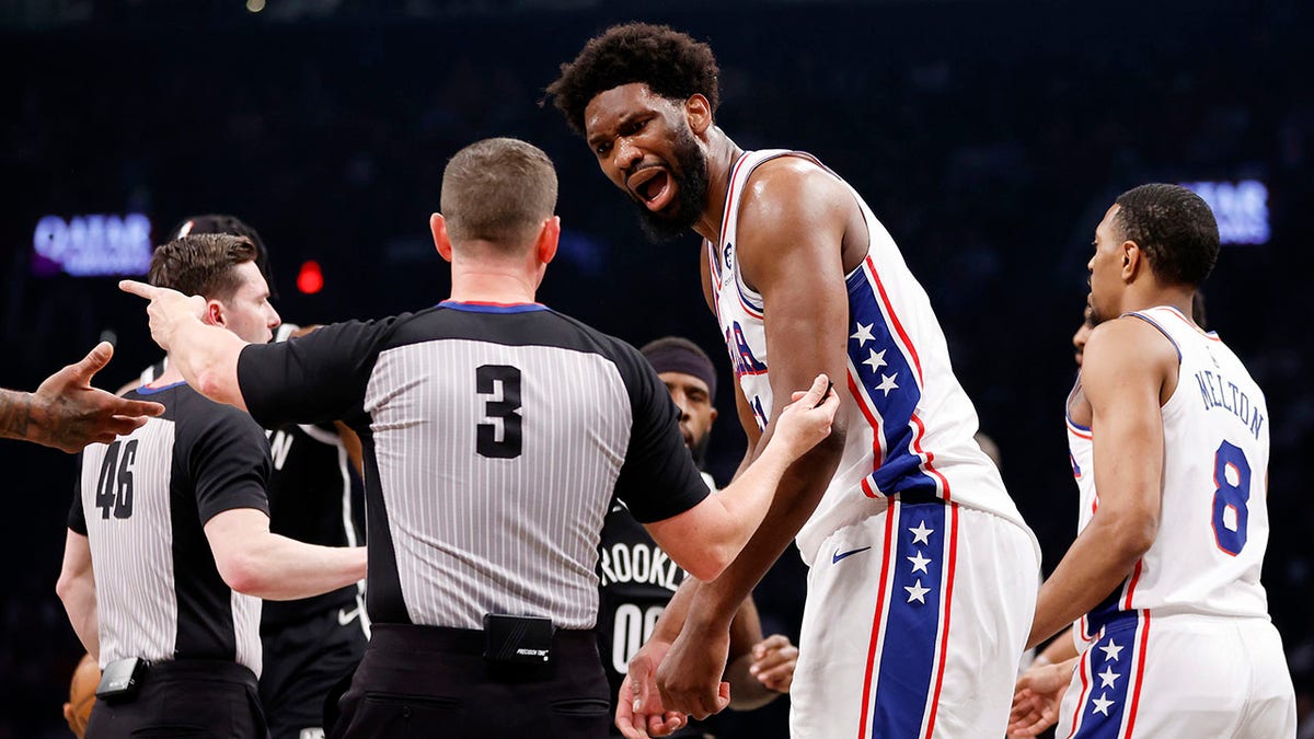 Joel Embiid talks to a referee