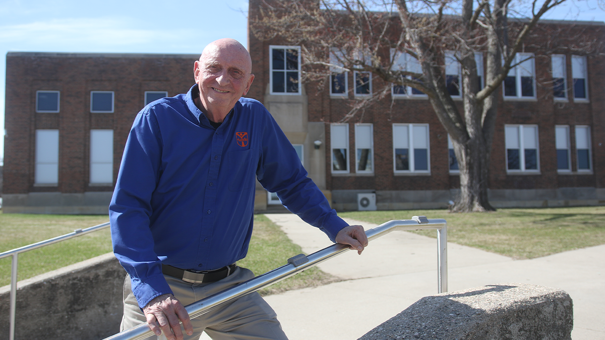 Jerry Sparby in front of school