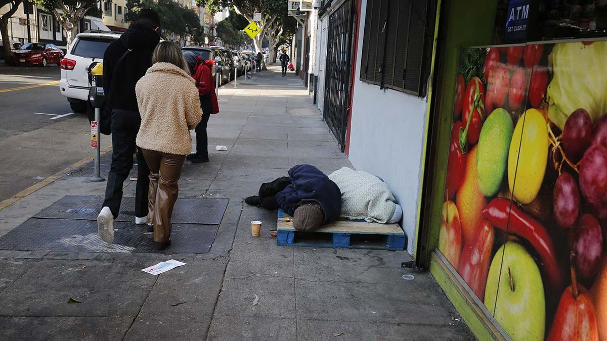 A homeless person sleeping on the street during the state of emergency.