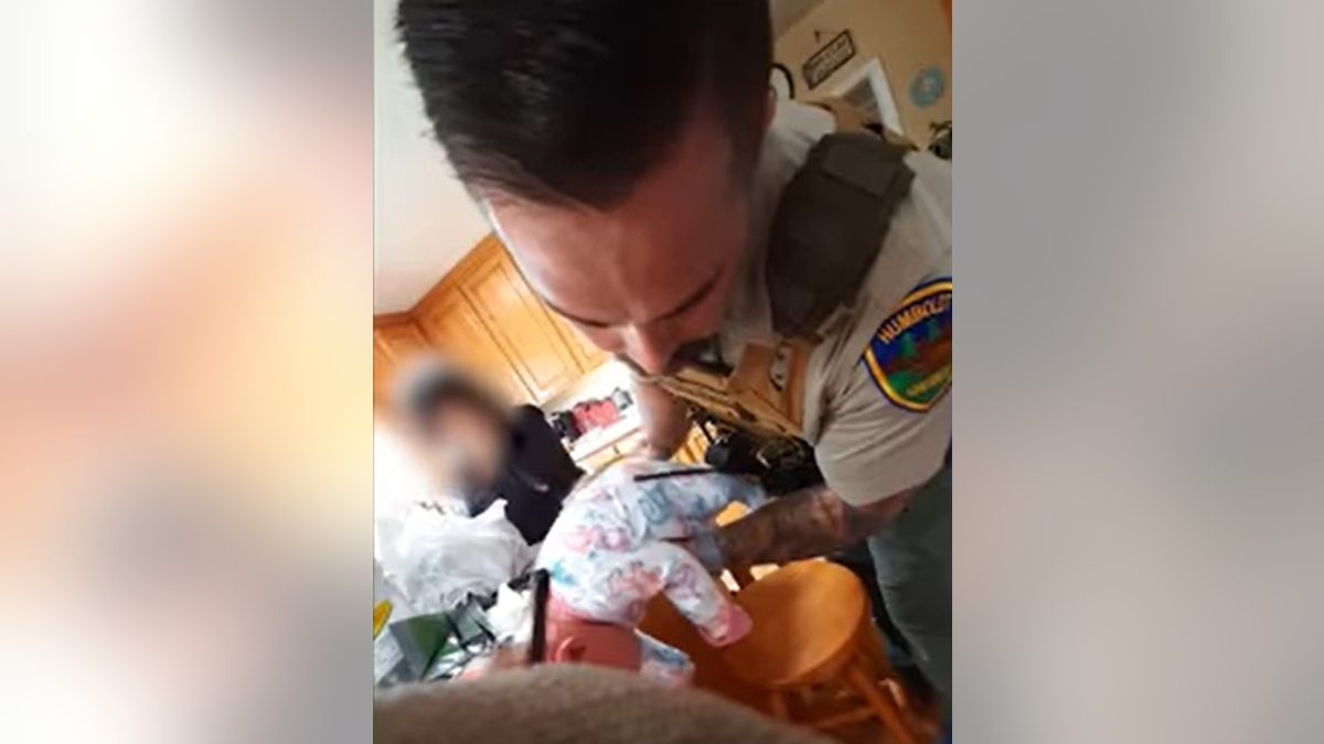 Detective performing CPR on baby