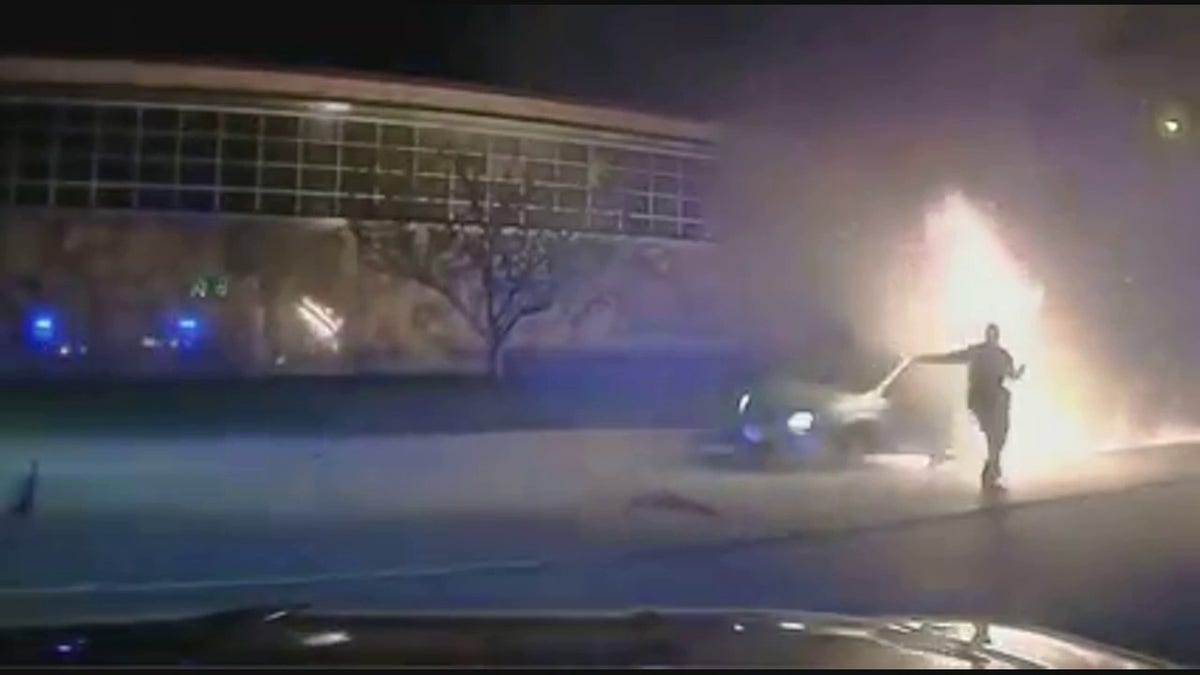officer running toward burning minivan