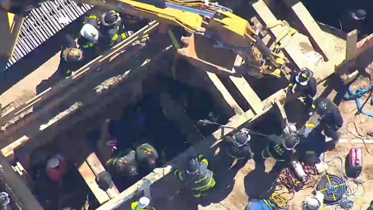 First responders climbing down a trench.