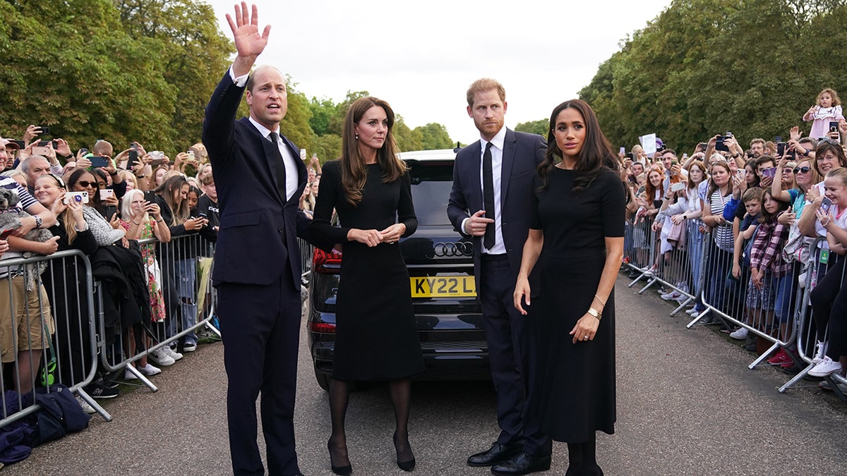 Kate Middleton, Prince William, Prince Harry and Meghan Markle standing in front of a car wearing black
