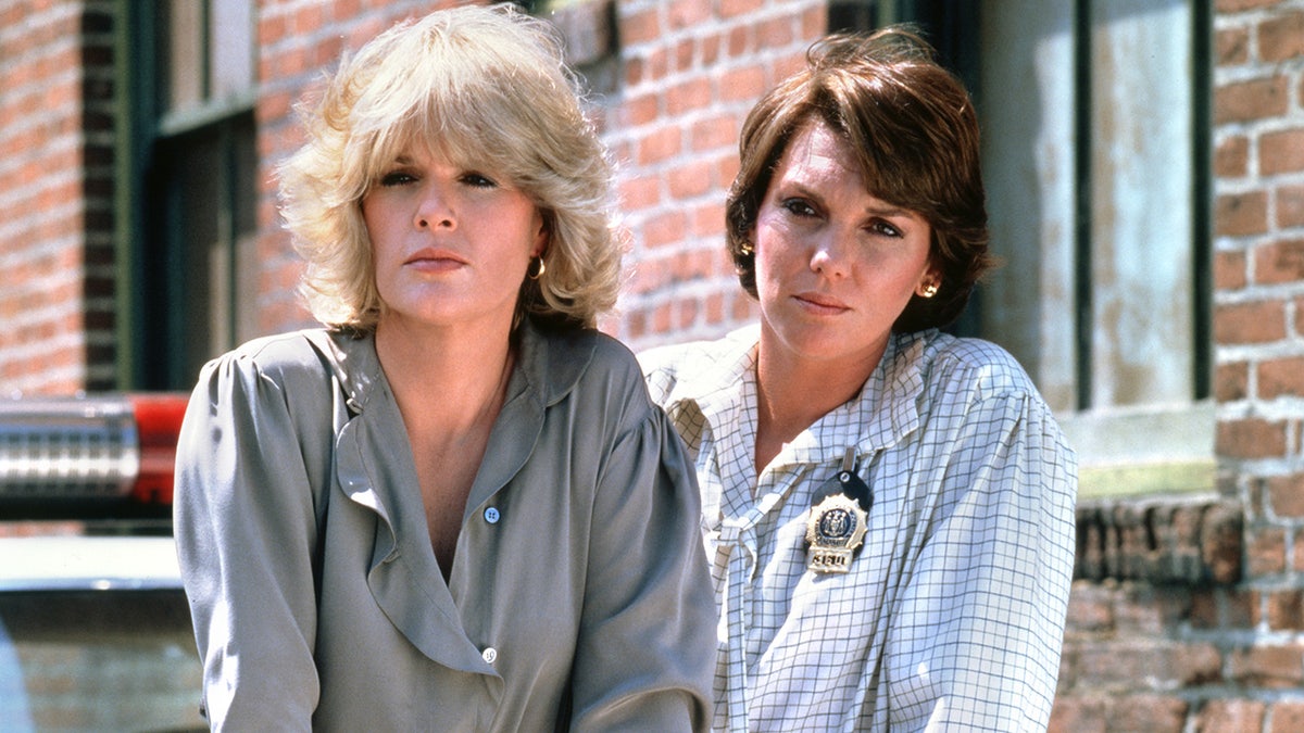 Cagney and Lacey stars wear badges in front of precinct