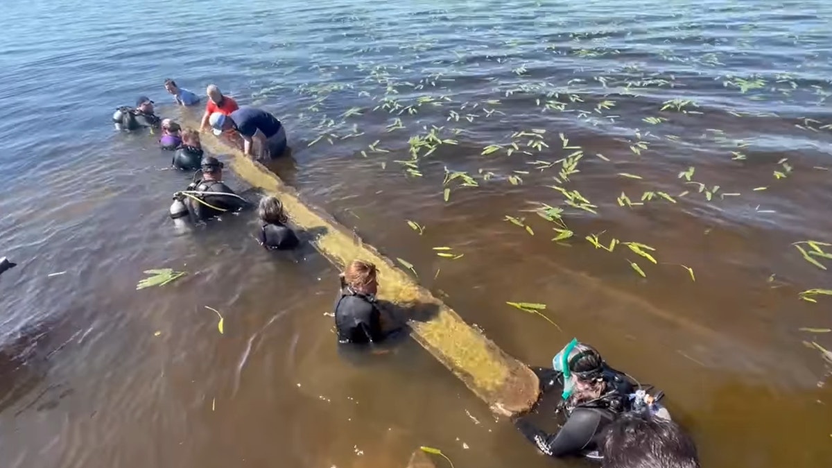 Divers retrieving the 28-foot long canoe