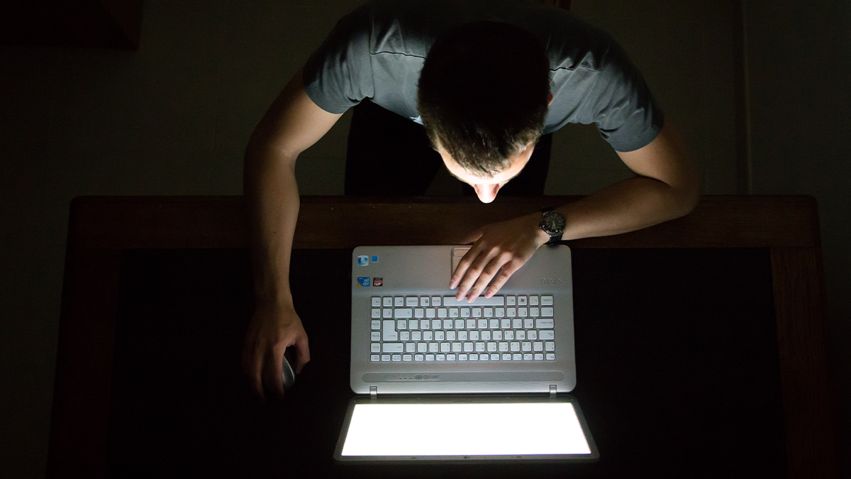 Man on laptop computer at night