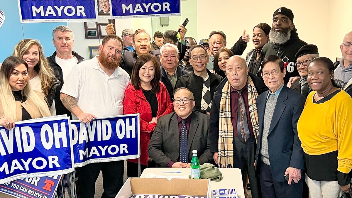 Philadelphia mayor candidate David Oh surrounded by supporters, many holding yard signs