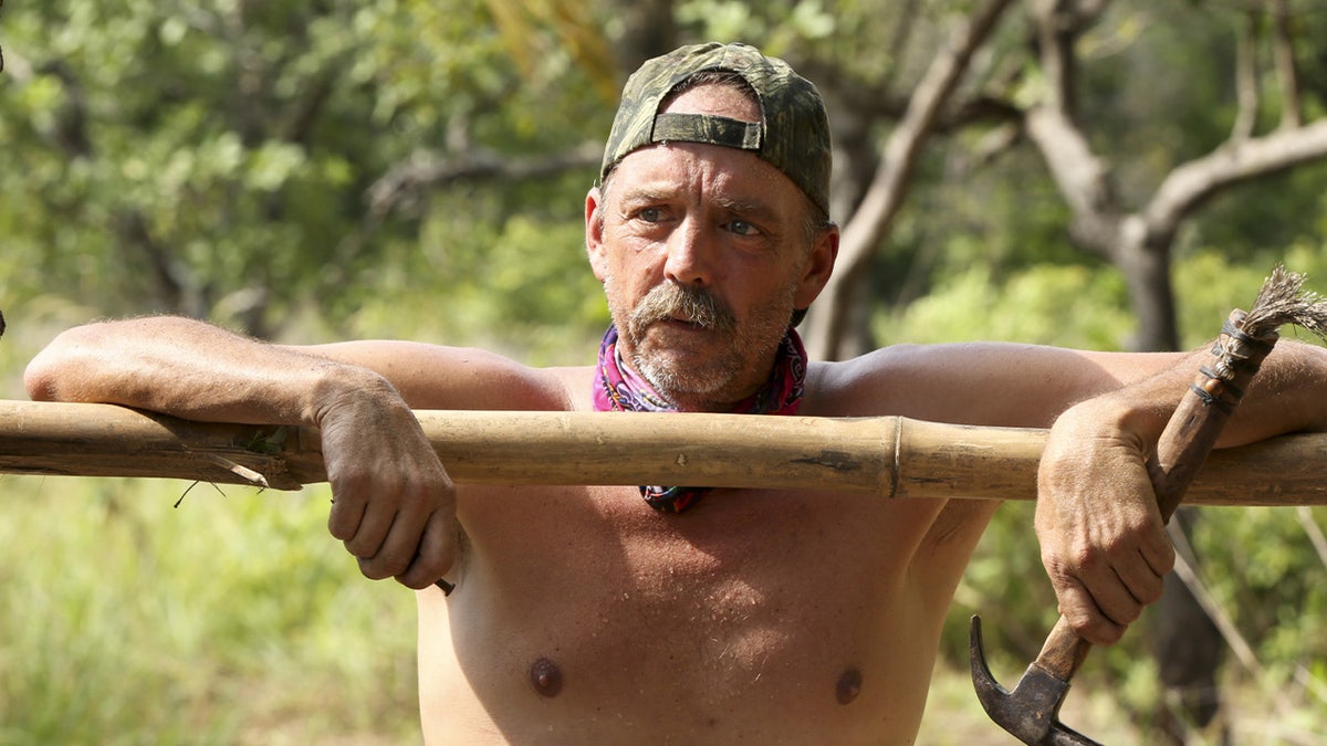 Keith Nale leaning while holding a hammer