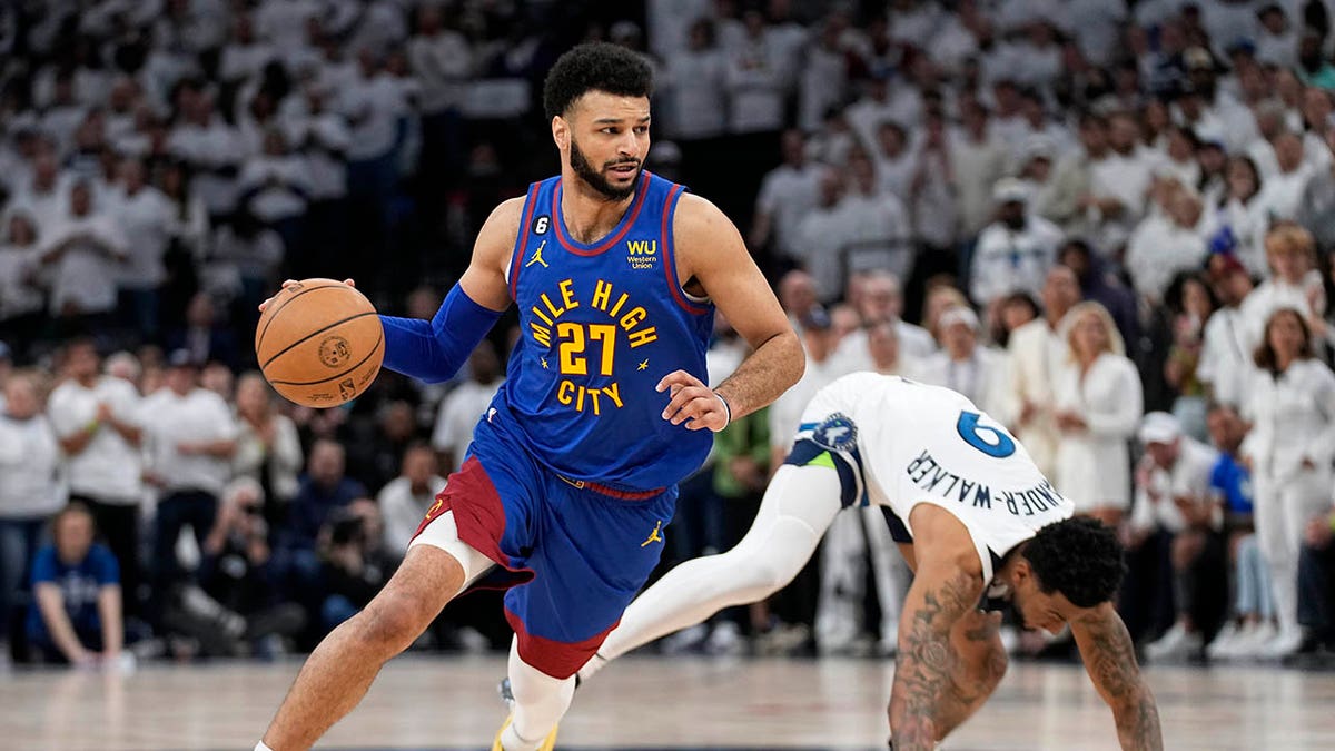 Denver Nuggets guard Jamal Murray (27) dribbles toward the basket against Minnesota Timberwolves guard Nickeil Alexander-Walker during the first half of Game 3 of an NBA basketball first-round playoff series Friday, April 21, 2023, in Minneapolis. 