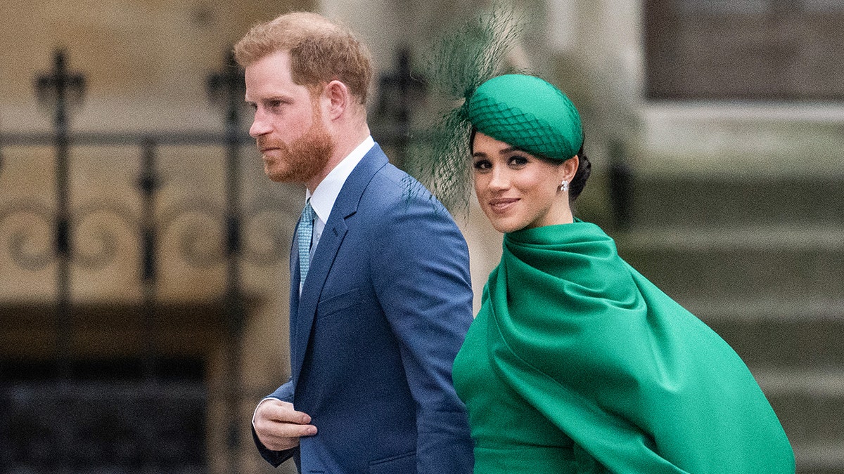 Meghan Markkle wearing a green dress holding Prince Harrys hand