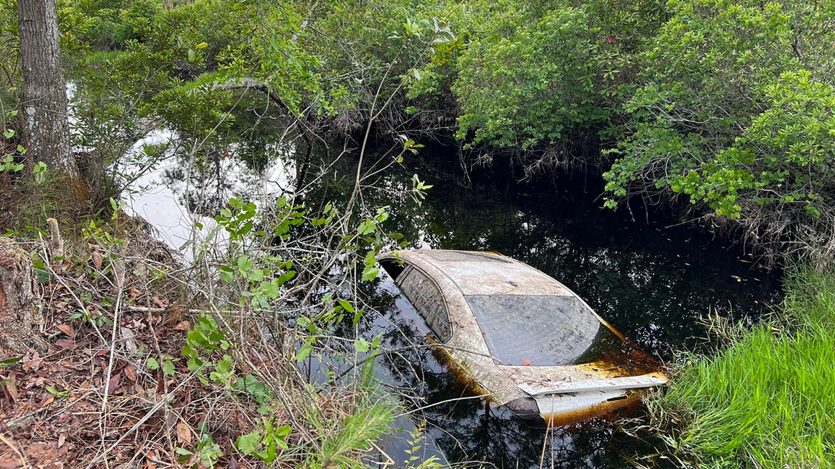 car partially submerged in canal