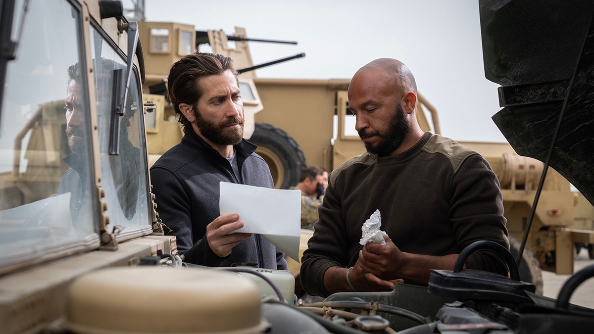 Jake Gyllenhaal and Dar Salim standing next to a miitary jeep in "The Covenant."