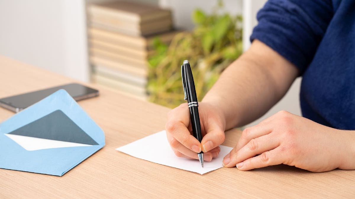 Man prepares to write on blank card