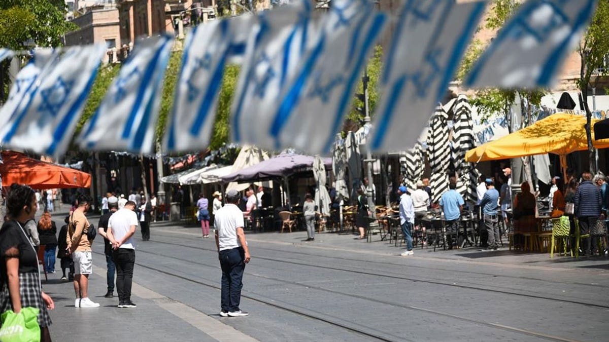 Streets in Israel lined with Israeli flags and people in silence