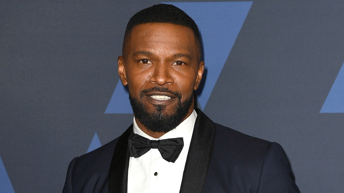 Jamie Foxx wears a bowtie and blue suit on the red carpet at film premiere