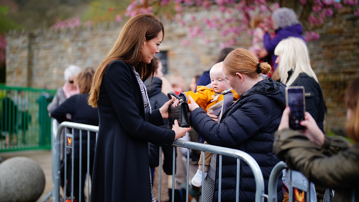 Kate Middleton in black for Aberfan; Adorable baby swipes her bag!