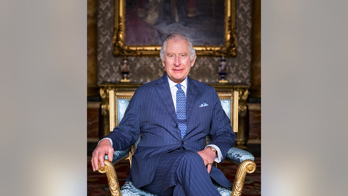 King Charles seated in Buckingham Palace