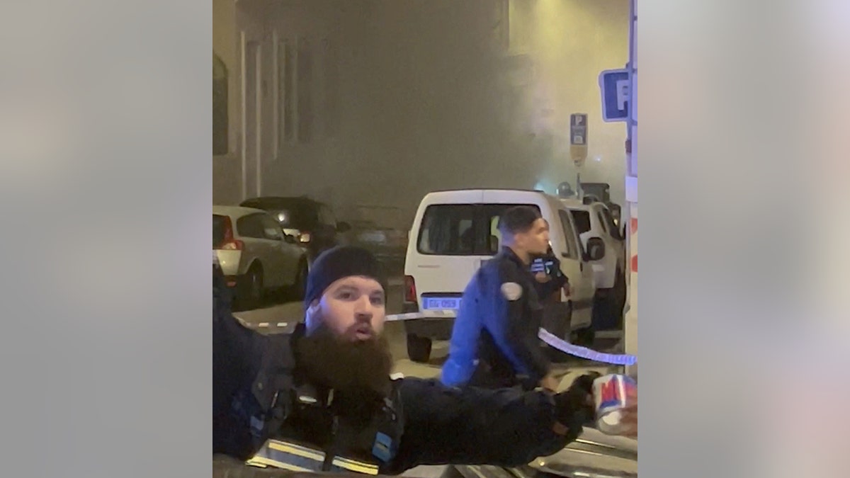 Police officers at smoky scene of building collapse