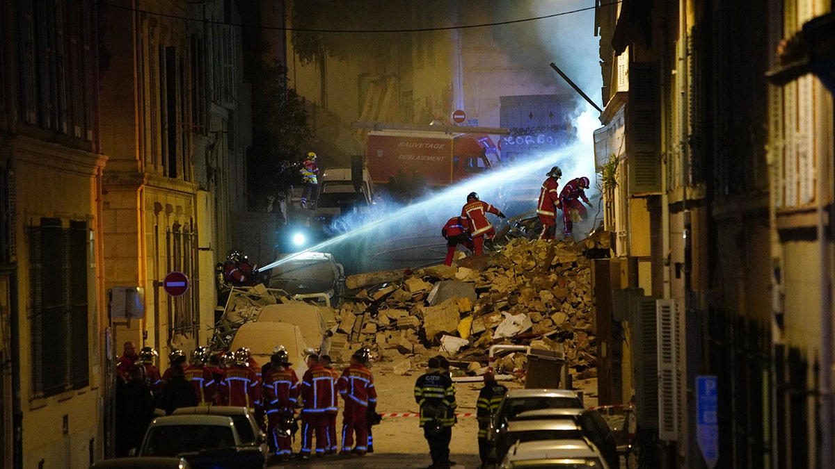 firefighters on top of rubble at building collapse