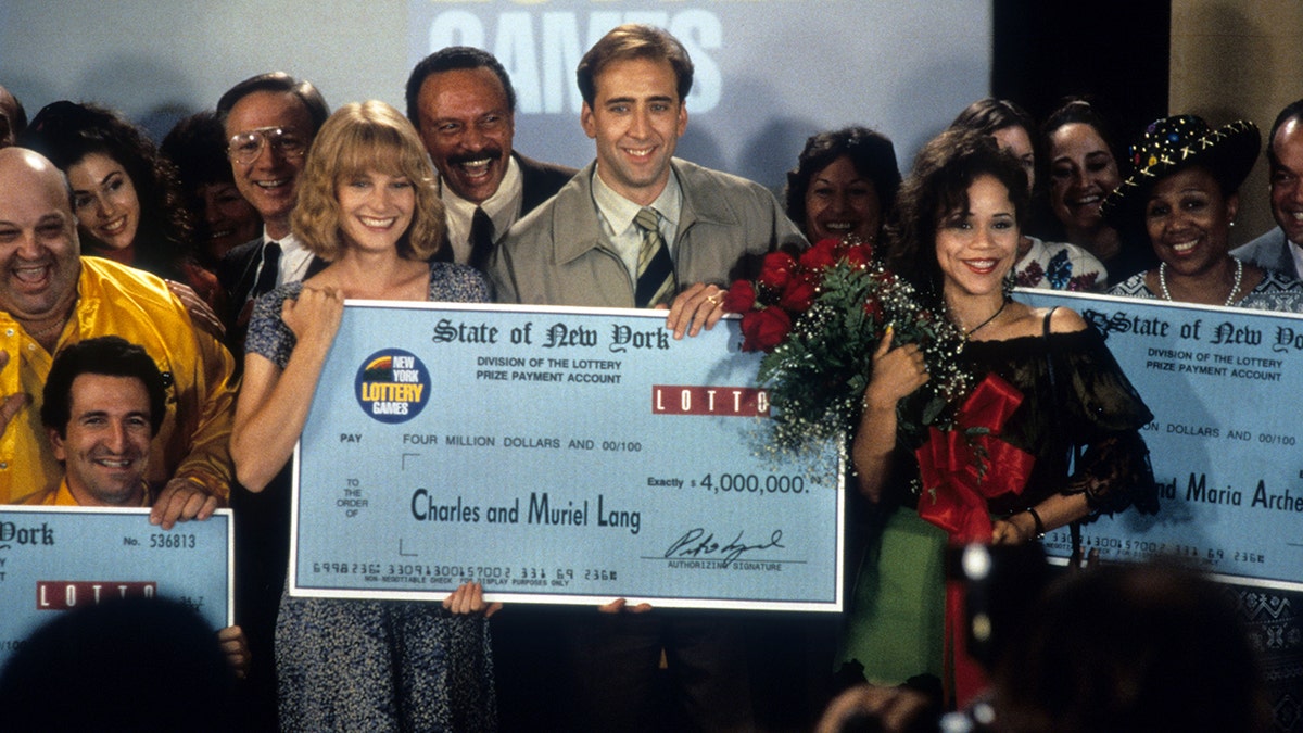 Bridget Fonda holds a lottery check with Nicolas Cage in It Could Happen to You movie still