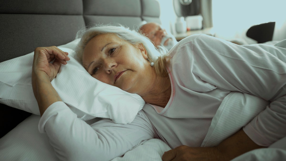 Older woman lying awake in bed