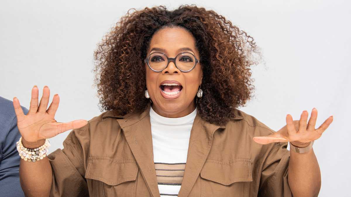 Oprah Winfrey waves her hands animatedly at an event.