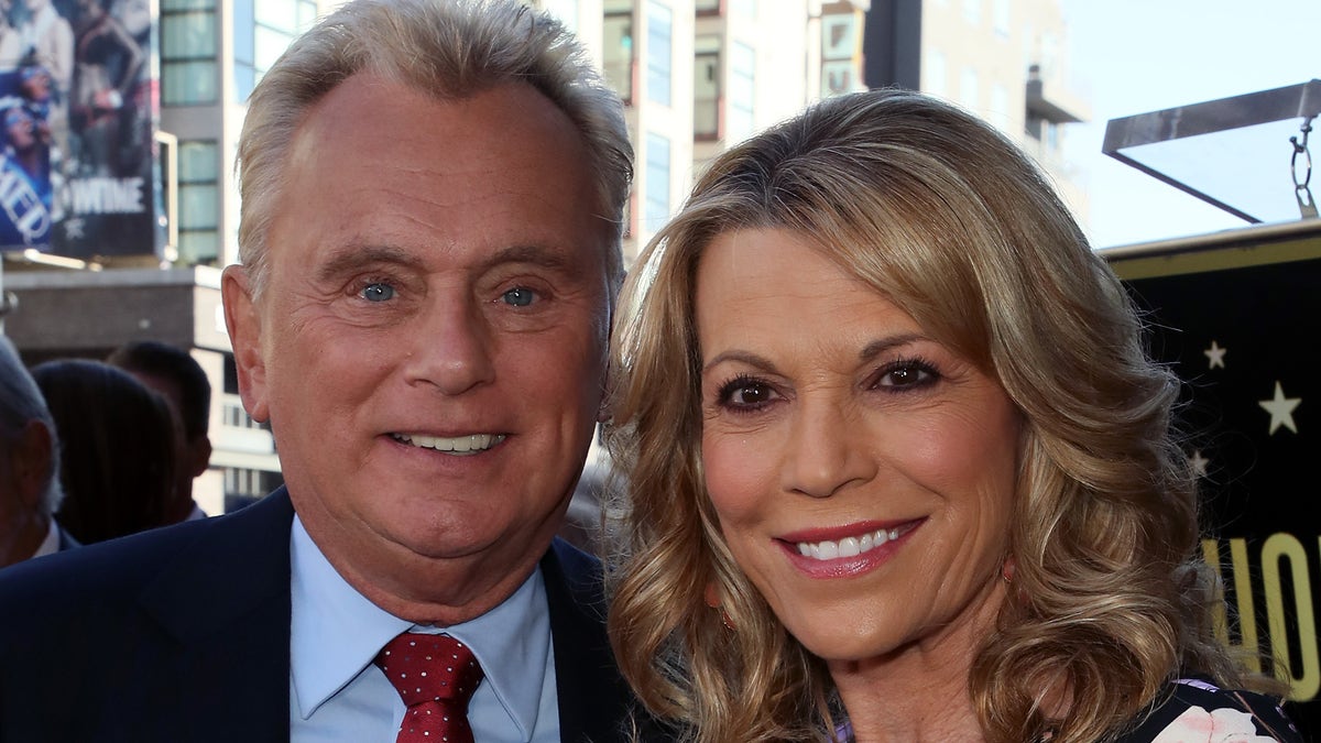 Pat Sajak and Vanna White post for a photo together on the Hollywood Walk of Fame