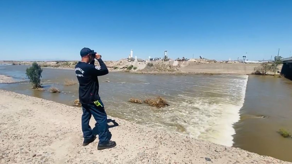 rescuer searching river from bank