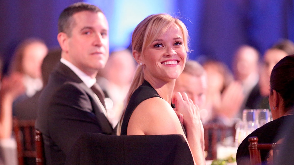 Reese Witherspoon smiles at awards show with Jim Toth in background