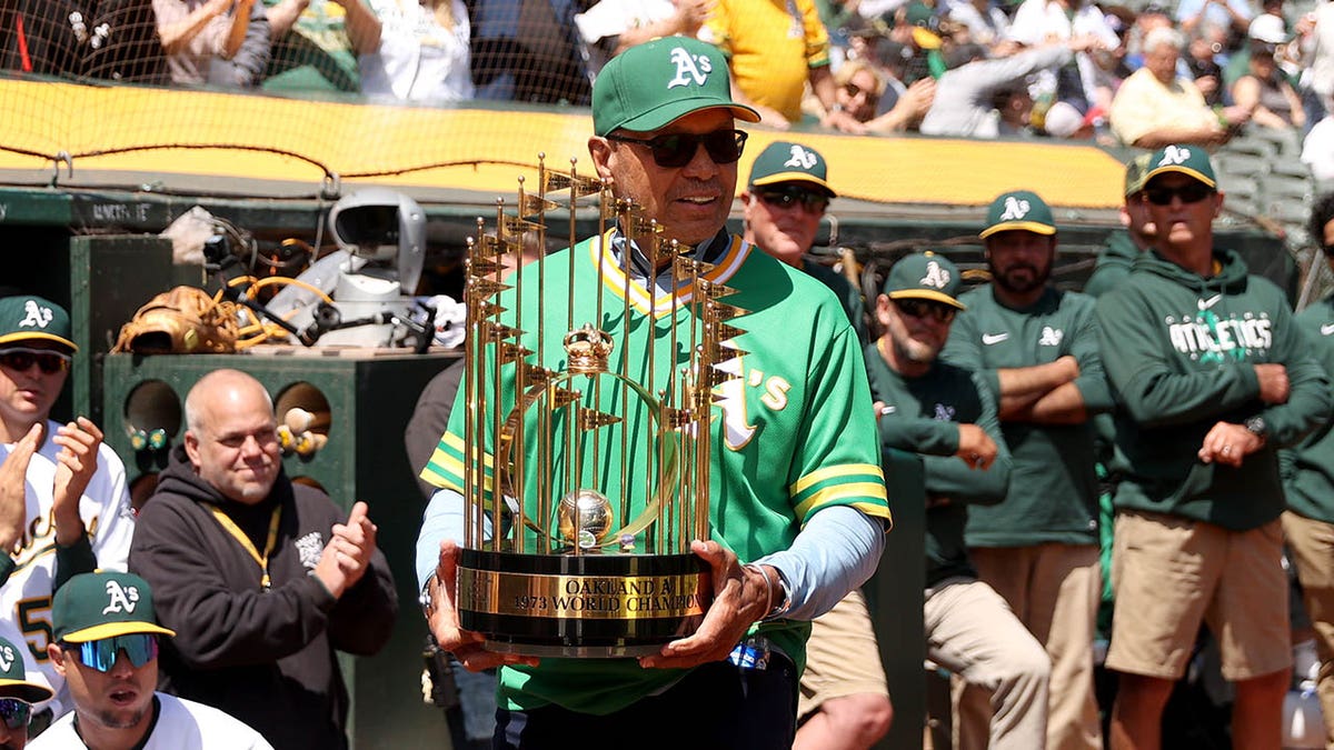 Reggie Jackson with world series trophy