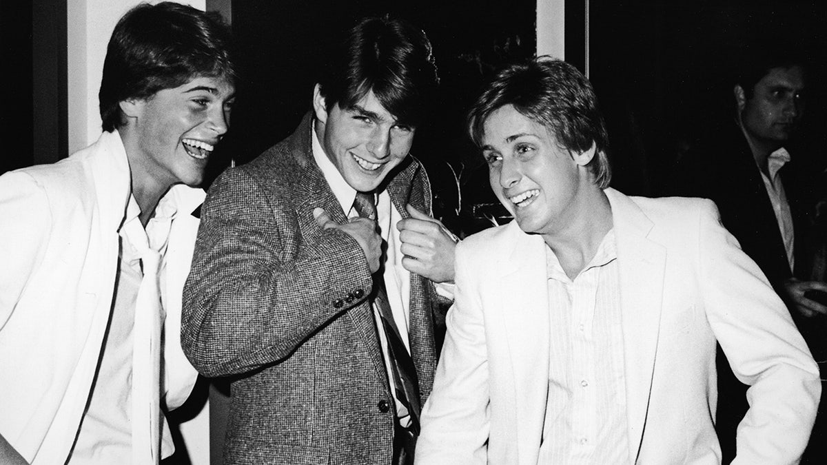 Tom Cruise, Emilio Estevez and Rob Lowe smile at a party in black and white photo