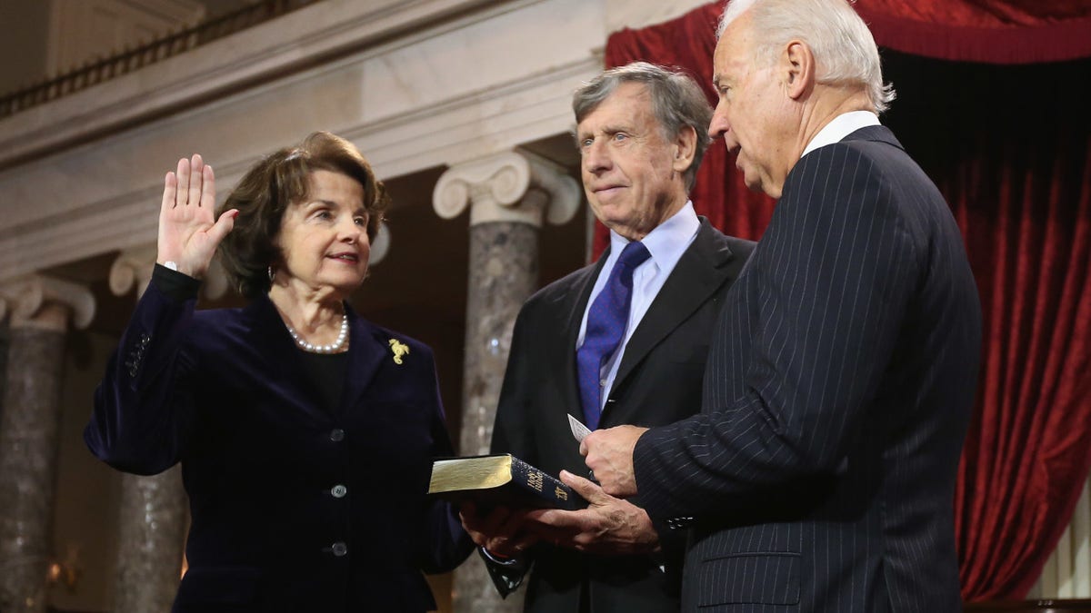 S. Sen. Dianne Feinstein (D-CA) (L) participates in a reenacted swearing-in with her husband Richard C. Blum and U.S. Vice President Joe Biden in the Old Senate Chamber at the U.S. Capitol January 3, 2013 in Washington, DC.