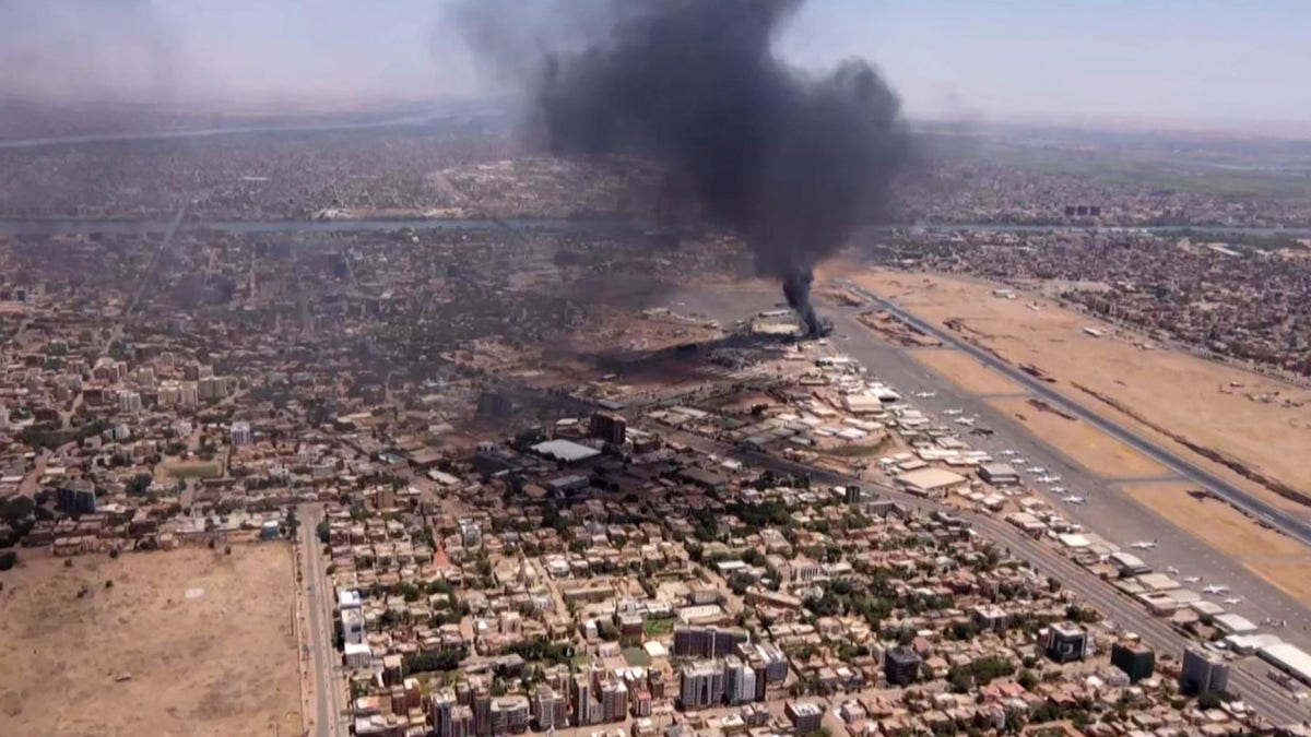 This image grab taken from AFPTV video footage on April 20, 2023, shows an aerial view of black smoke rising above the Khartoum International Airport