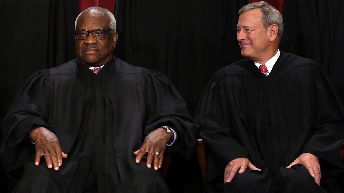 Justice Clarence Thomas, left, and Chief Justice John Roberts, right