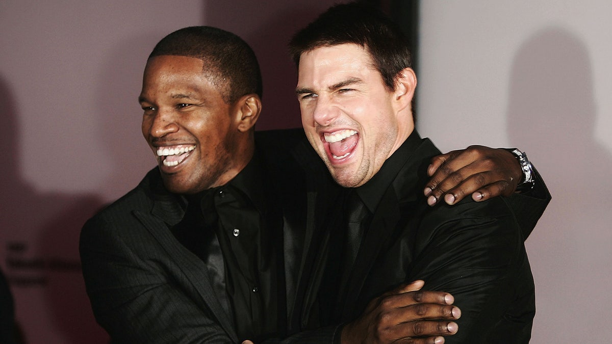 Tom Cruise and Jamie Foxx hug and laugh at film festival
