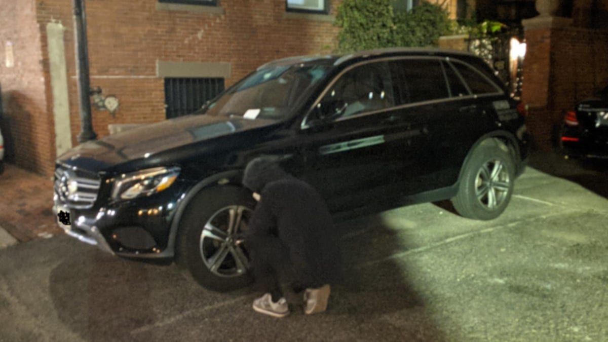 A climate activist deflates an SUV tire in Boston