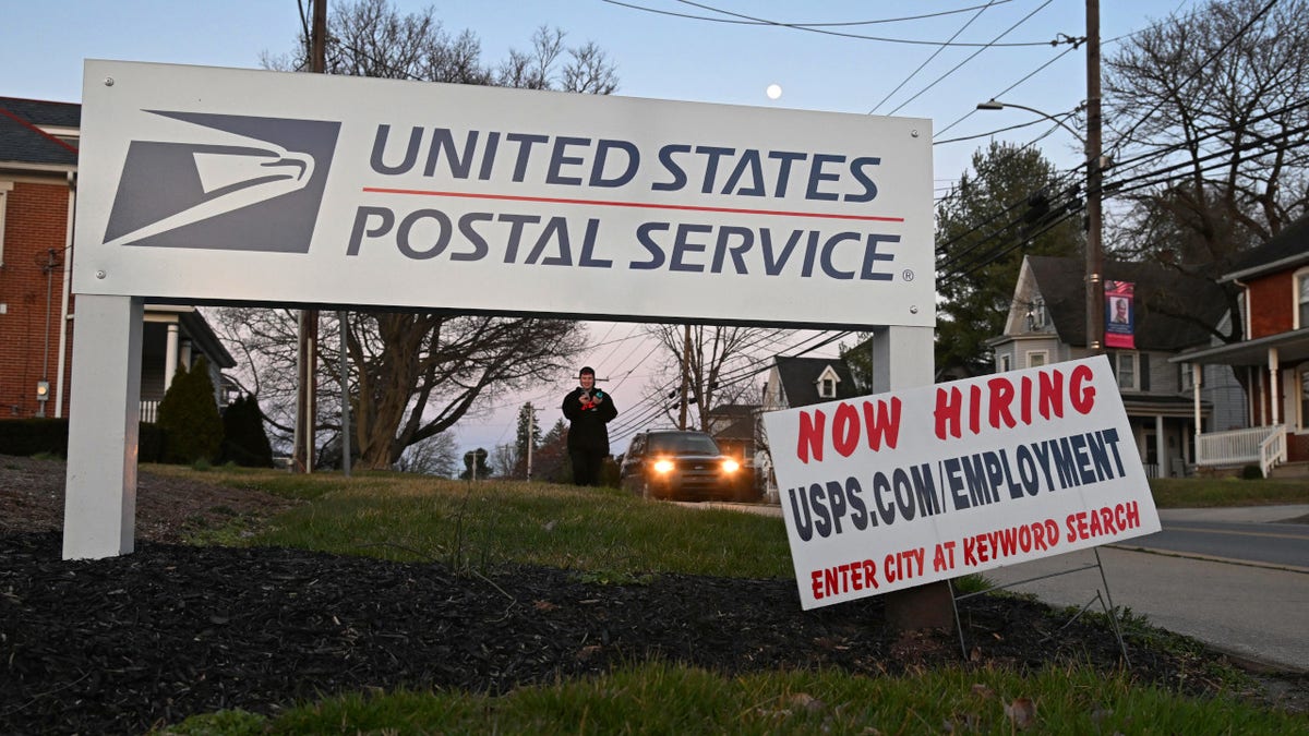 A USPS 'Now Hiring' sign