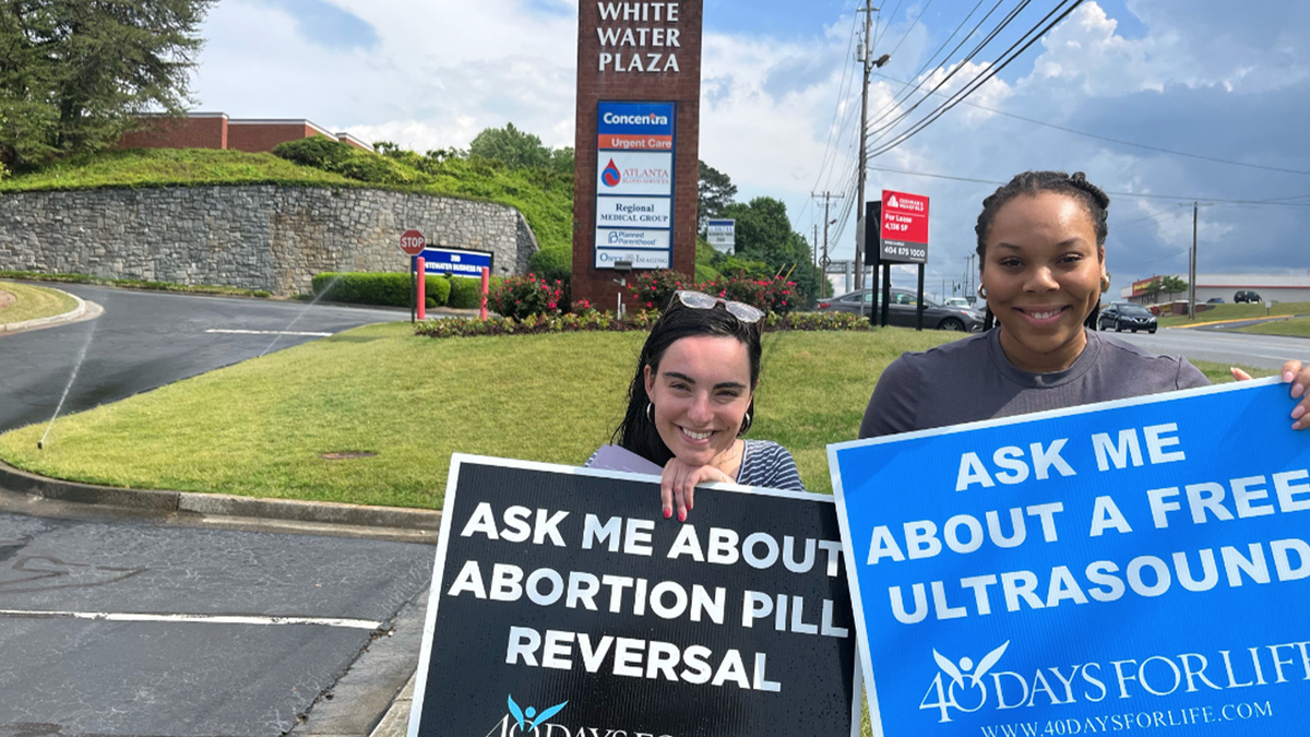 Pro-lifers holding signs at shopping center