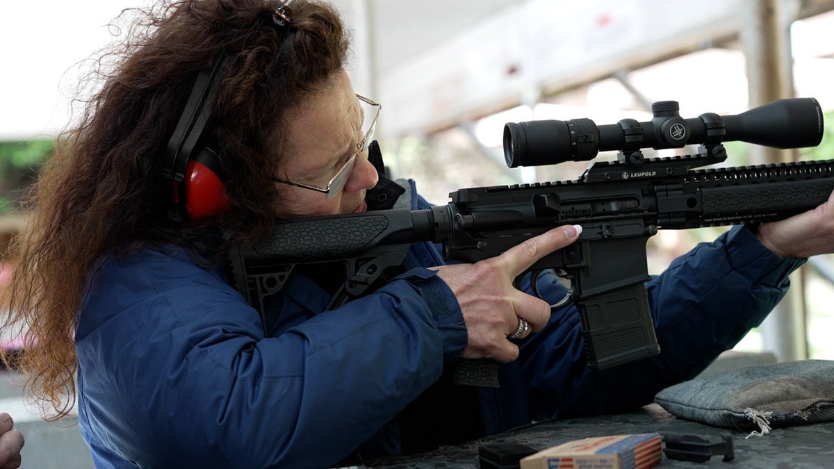 Woman learns to shoot AR-15 at outdoor rifle range