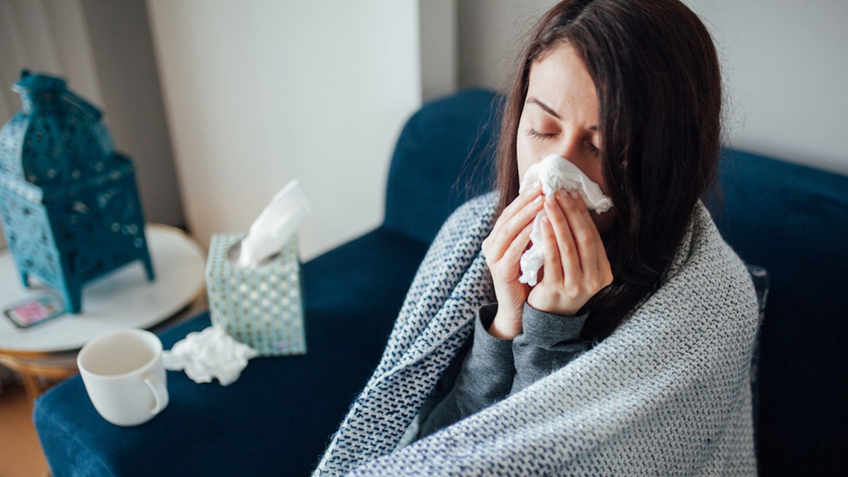 Woman blowing nose