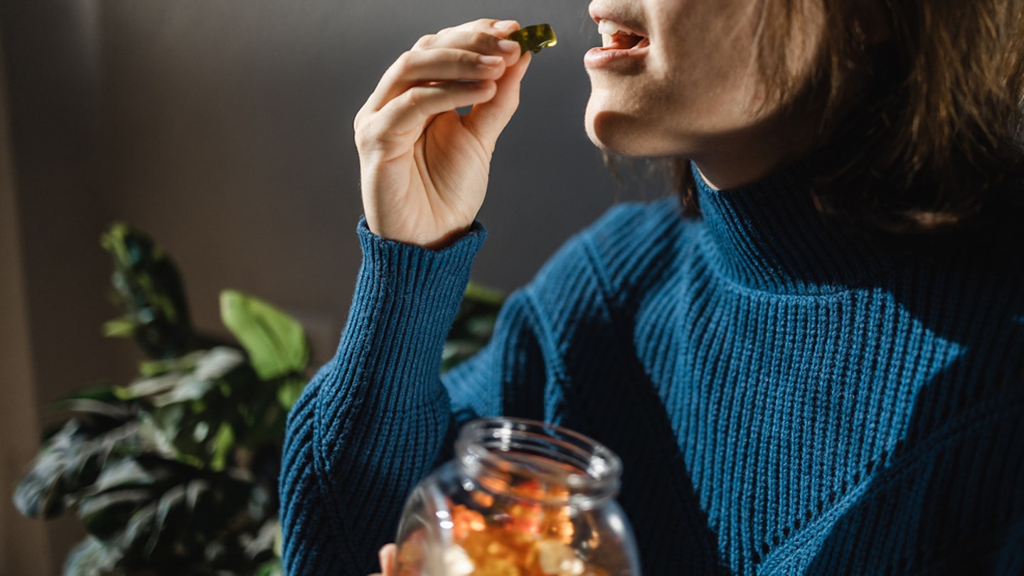 woman taking gummy vitamins