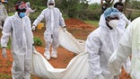 Forensic experts and homicide detectives carry the bodies of suspected members of a Christian cult named as Good News International Church, who believed they would go to heaven if they starved themselves to death, after their remains were exhumed from their graves in Shakahola forest of Kilifi county, Kenya, April 22, 2023. REUTERS/Stringer