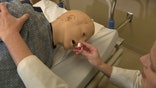 A doctor shows how to use Narcan on a dummy.