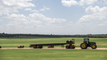 A tractor collects bales of hay during a heatwave outside Elgin, Texas, US, on Wednesday, July 20, 2022. In Texas 100-degree Fahrenheit temperatures plus the soaring costs for feed, fertilizer, fuel and the lack of water and hay have made it too expensive for farmers to sustain livestock. Photographer: Sergio Flores/Bloomberg via Getty Images